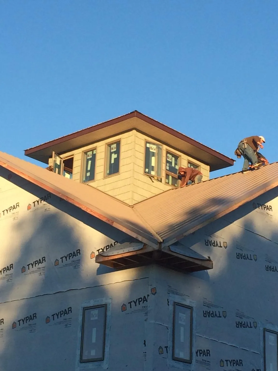 Roofers working around a rooftop cupola on a new metal roof at sunset — Roof Waterproofing in Playa Vista by Roofing Brothers